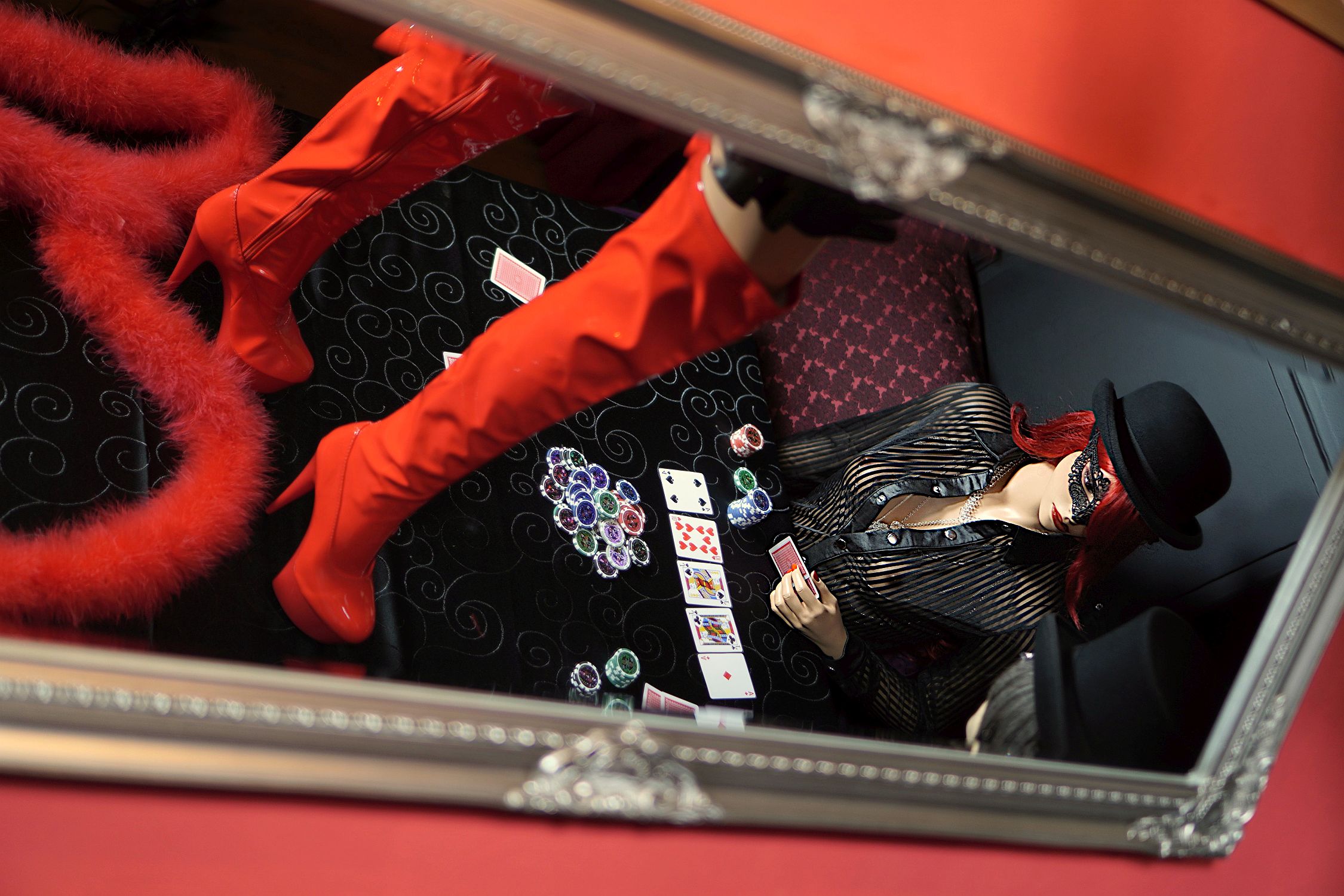 Rote Lackstiefel auf dem Pokertisch in der Boutique Burlesque